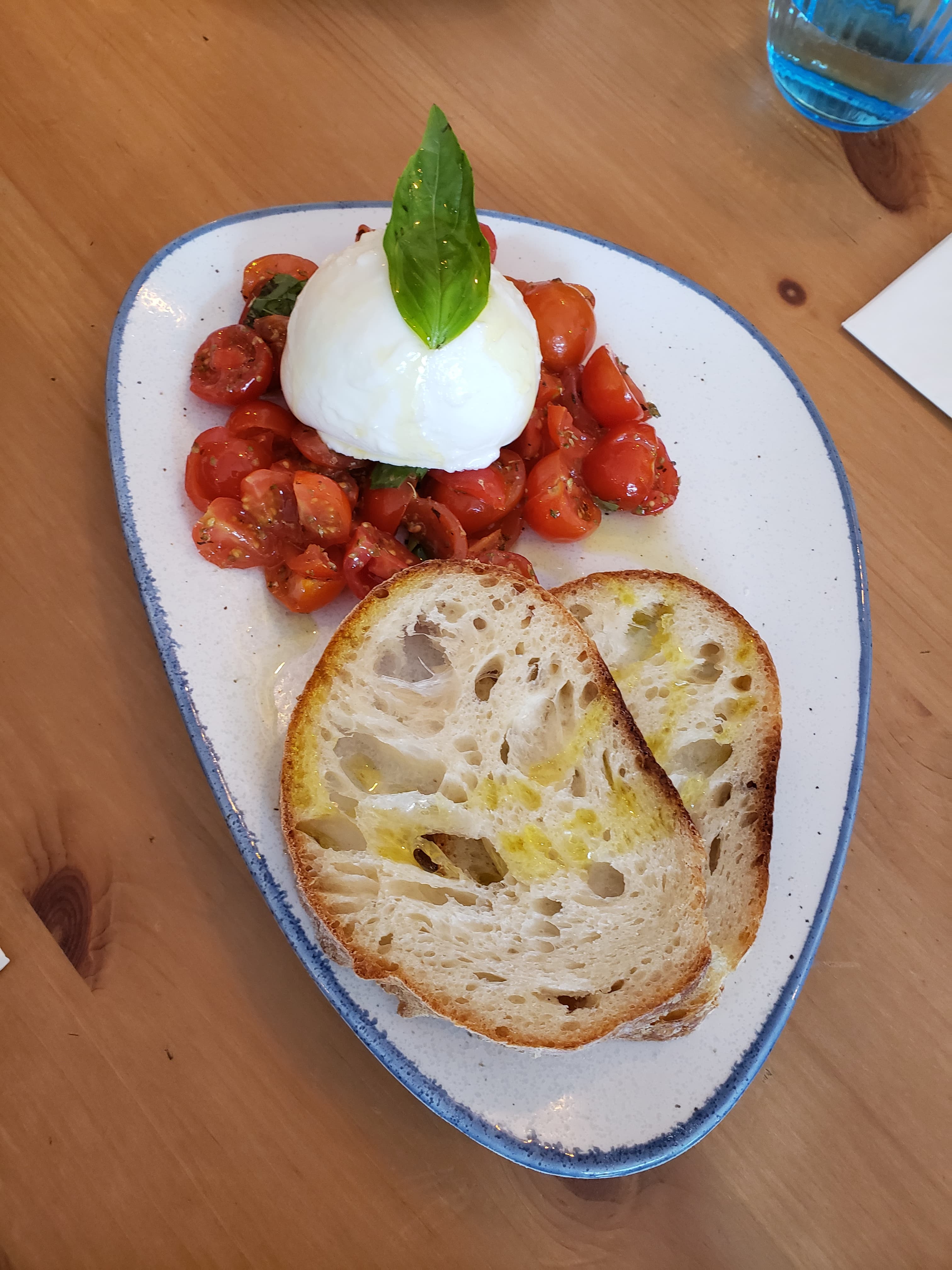 Fresh burrata with cherry tomatoes, rocket, basil, and bread